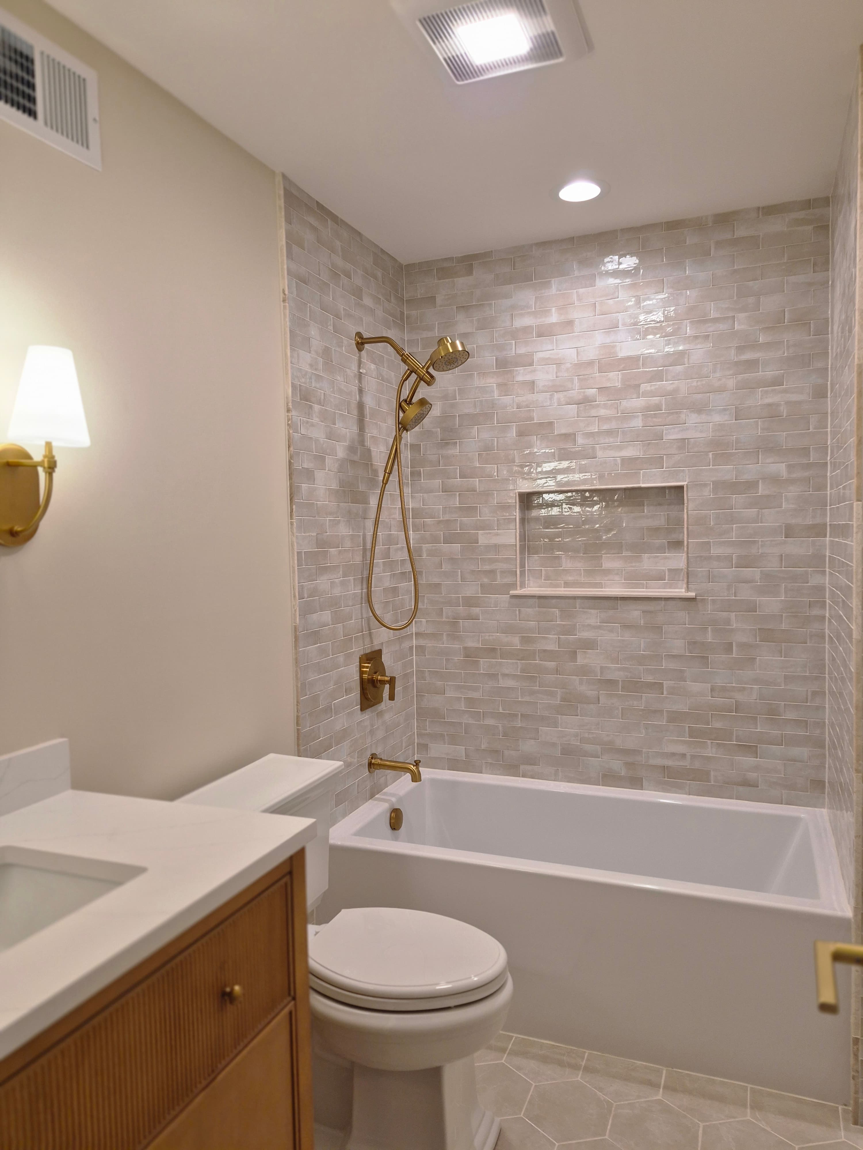 A tiled tub with brass fixtures, clean and bright
