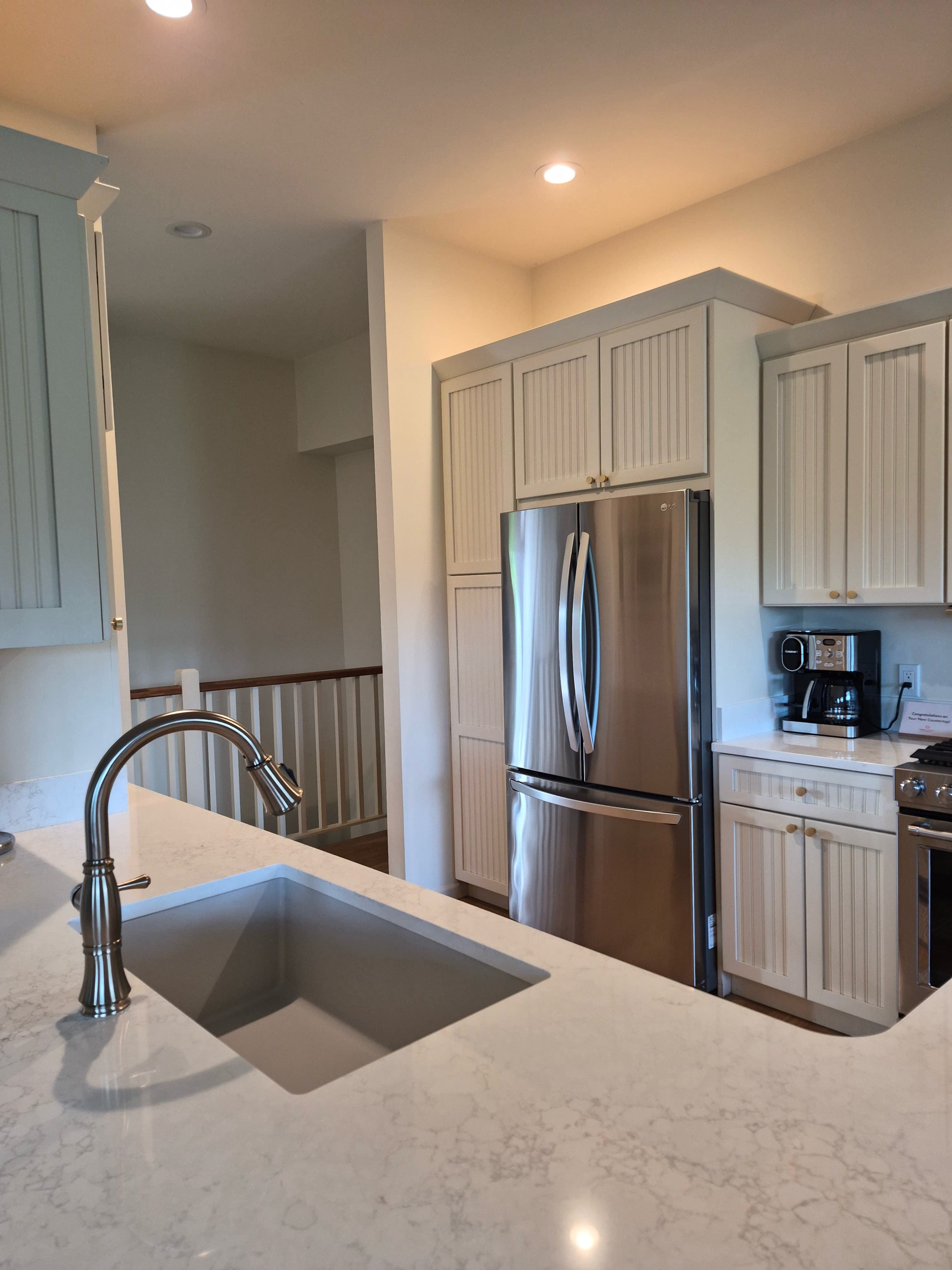 A kitchen island and sink, wiped and shining